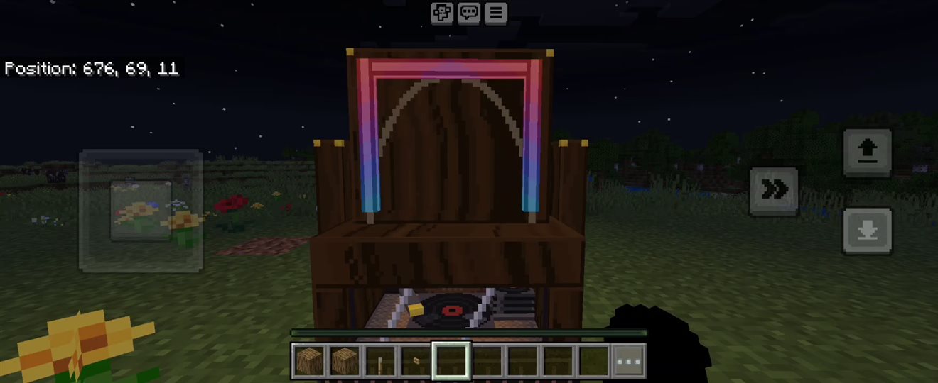 The Big Jukebox playing at night on Bedrock mobile, with the record visible through the window and the neon arch lit